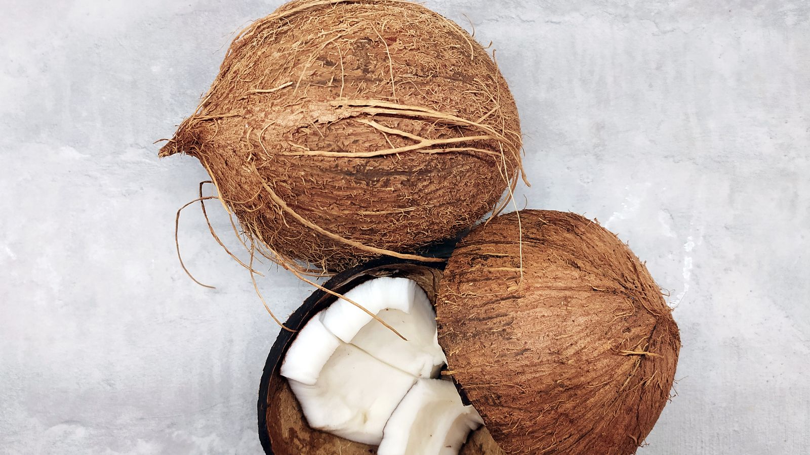 Fresh coconut and a jar of coconut oil, illustrating coconut oil benefits