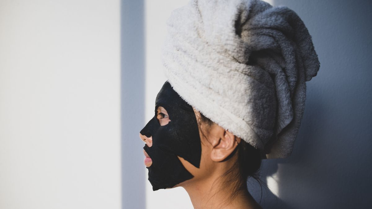 A woman applying a coconut oil and honey face mask for glowing skin